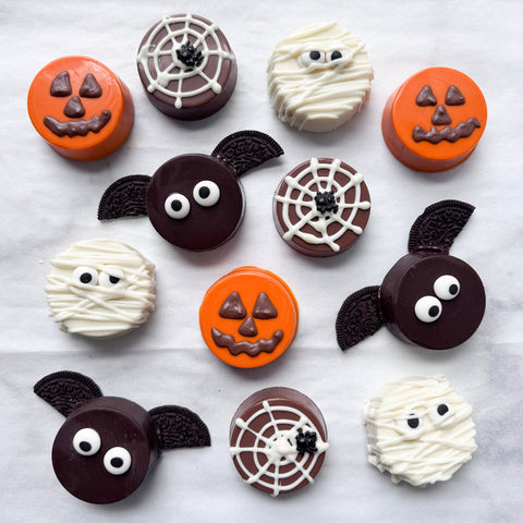 Halloween chocolate covered oreos made with a sandwich cookie mold including white chocolate mummies, dark chocolate bats with oreo wings, orange jack-o'-lantern pumpkins, and spider webs topped with black edible sprider sprinkles