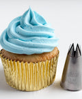 1M piping tip along side a cupcake with light blue buttercream frosting swirl in a gold foil cupcake liner.