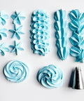 A flat-lay of light blue piped frosting  and a metal 1M piping tip on a white background, showing star, ruffle, rosette, and swirl patterns.