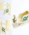 3D chocolate sleigh with holly and berries along side 3D sleigh candy mold two part set