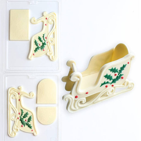 3D chocolate sleigh with holly and berries along side 3D sleigh candy mold two part set