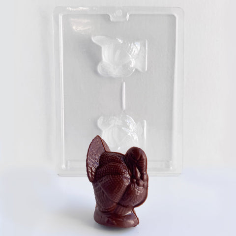 medium 3d turkey chocolate mold with a dark chocolate molded turkey in front of it. The turkey mold and finished turkey have texture and fine detail.