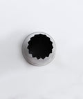 Over head shop of  the 6B pastry tip or piping nozzle with a dark star-shaped opening, photographed from above on a clean white background.