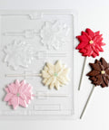 Poinsettia pop candy mold with chocolate poinsettia lollipops next to it.