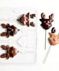 Chocolate reindeer lollipops with a plastic chocolate mold on a white background