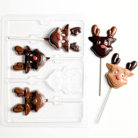 Chocolate reindeer lollipops with a plastic chocolate mold on a white background
