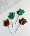 cactus lollipops made from chocolate along side a plastic candy mold