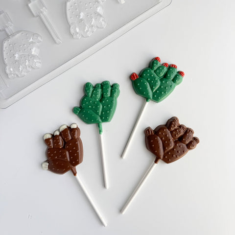 cactus lollipops made from chocolate along side a plastic candy mold