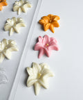 Easter lily shaped chocolates along side the plastic candy mold for making them.