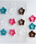 flower blossom plastic candy mold next to colorful molded flower chocolates