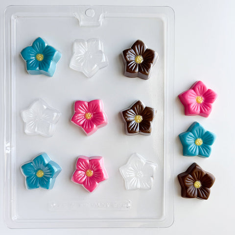 flower blossom plastic candy mold next to colorful molded flower chocolates