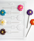 flower lollipop plastic candy mold with classic flower shaped chocolate lollipops next to it.