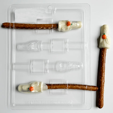 ghost pretzel rod chocolate mold with chocolate ghosts holding orange pumpkins