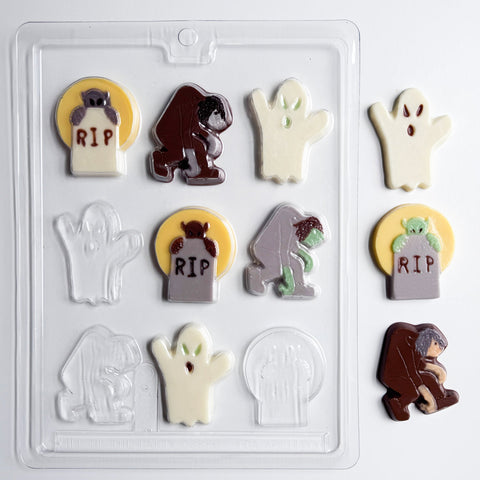 A Halloween-themed chocolate mold displayed on a white background, featuring various spooky shapes like ghosts, tombstones with 'RIP' text, a zombie, and a werewolf, shown both inside the clear plastic mold and as individual pieces.