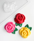 large rose pieces chocolate mold along side chocolates shaped like roses.