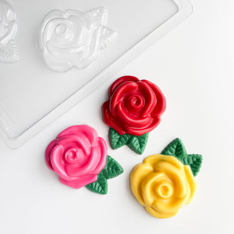 large rose pieces chocolate mold along side chocolates shaped like roses.
