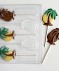 Chocolate lollipops shaped like palm trees with a mold on a white background