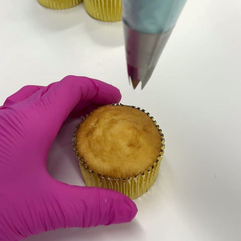 Showing how to use the 1M piping tip to pipe a swirl onto a cupcake