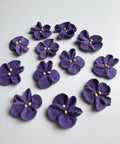 purple royal icing violets with two yellow dot centers. 