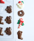 Small Christmas assortment candy mold is a plastic candy mold that makes chocolate pieces in the shape of Santa faces, candy canes, wreaths, and stockings.