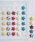 Star-shaped candy mold with chocolate stars next to plastic chocolate mold