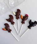Five chocolate turkey lollipops shown along side the small turkey lollipop mold used to make them