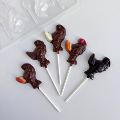 Five chocolate turkey lollipops shown along side the small turkey lollipop mold used to make them