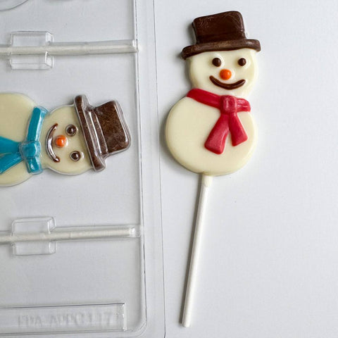 Smiling snowman lollipop made of chocolate next to plastic chocolate mold