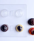 clear plastic sandwich cookiechocolate mold that makes chocolate molded oreos with little turkey molded on top. Two finished chocolate molded sandwich cookies to the right in dark chocolate and orange colored chocolate with an intricately painted turkey.